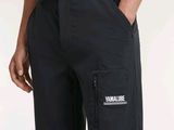 un gros plan sur une personne portant une chemise bleue et un pantalon noir