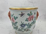 a white vase with a gold rim and flowers on it