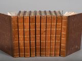 six old books stacked on top of each other on a table