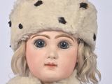 a doll that is wearing a fur hat and scarf
