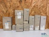 Plusieurs cartons sont empilés les uns sur les autres devant un mur en bois.