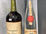 deux bouteilles de vin posées sur une étagère l'une à côté de l'autre