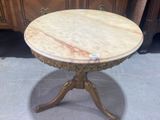 a marble top table with a wooden base on a floor