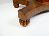 un banc en bois muni de roulettes, posé sur une surface blanche