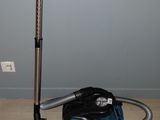 un aspirateur posé par terre à côté d'un sac
