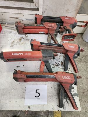 quatre outils à main rouges et noirs posés sur une table