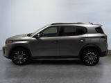 the silver suv is parked in a room with a light blue wall