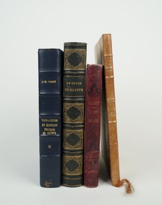 several old books are stacked on top of each other on a white surface
