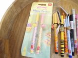 a wooden table with pens and pencils sitting on top of it