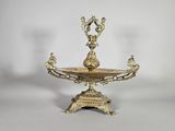 an antique brass candle holder with two birds on it