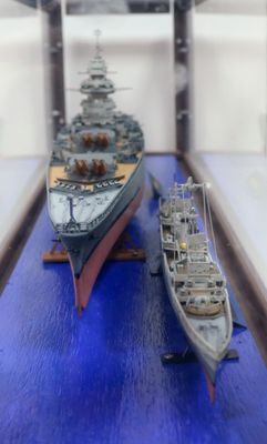 two model ships on display in a glass case