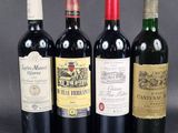 four bottles of wine are lined up on a table