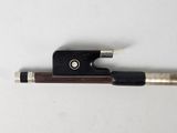 a violin bow with a wooden handle on a white surface