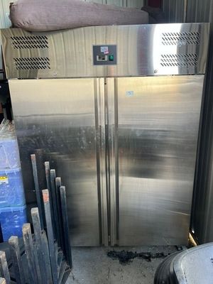 a large stainless steel refrigerator in the middle of a pile of boxes