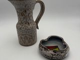 a small pitcher and a small bowl sitting next to each other