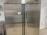 two stainless steel refrigerators in a kitchen with tile flooring