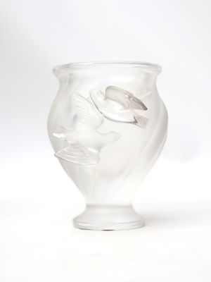 a glass vase with a face on it on a white surface