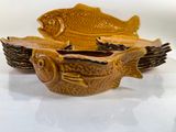 two bowls with fish on them on a white surface
