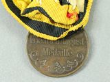 a gold medal with a black and yellow ribbon around it