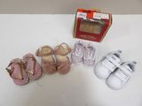 plusieurs paires de chaussures de bébé posées sur une table à côté d'une boîte
