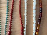 several different colored beads are arranged on a wooden surface
