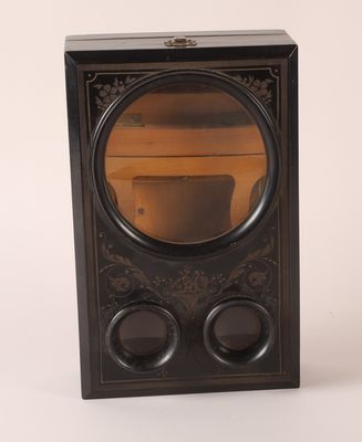 une image représentant une horloge noire dans laquelle on voit un miroir