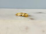 La bague en or est posée sur une table en marbre.