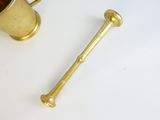 a gold cup and a brass pipe on a white table