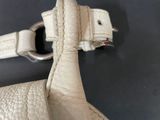 a close up of a white purse with a silver buckle