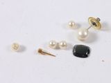 several different types of earrings and pins on a white surface