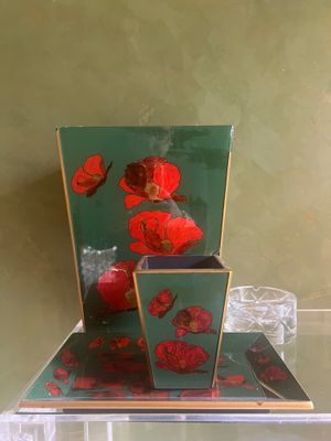 une table en verre sur laquelle se trouve un vase contenant des fleurs rouges