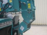 a blue crane that is parked in front of a building