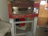 an image of a kitchen with a stove and a trash can