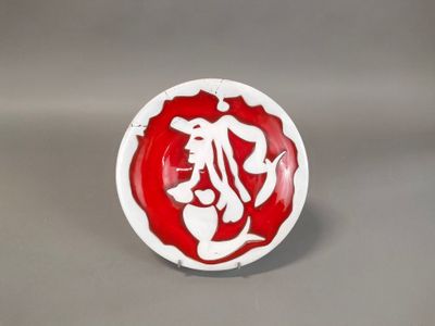 a red and white plate with a picture of a woman on it