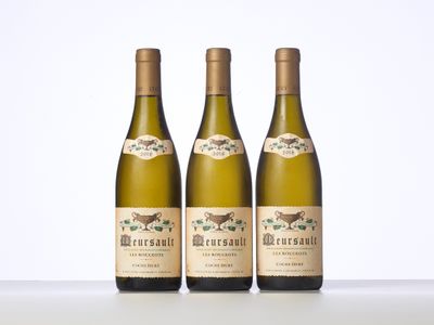 three bottles of wine sitting on top of a white table