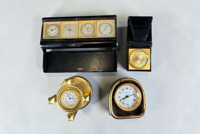 three clocks and a box on a white surface