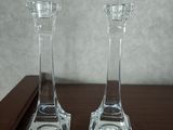 deux bougeoirs en verre transparent posés sur une table en bois