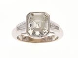 une photo d'une bague en diamant avec un diamant taille baguette au centre