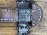 an old leather belt with a metal buckle on a wooden surface