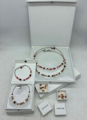 une boîte blanche contenant un collier, un bracelet et un bracelet