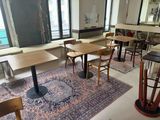 des tables et des chaises dans une pièce où il y a un tapis au sol