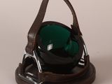 a black and green glass bowl on a brown holder