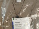 a brown shirt with a tag on it sitting on a table