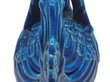 a blue vase with a bird on it on a white background