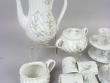 a white tea set with blue flowers on it