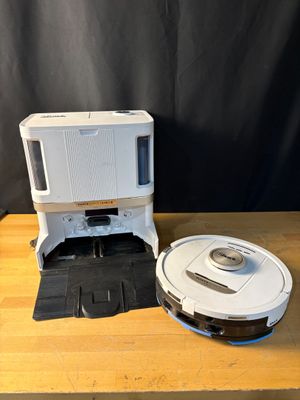 an image of a robot vacuum and a microwave sitting on a table