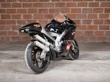 a black motorcycle parked in front of a brick wall
