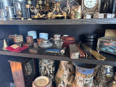 de nombreux vases et autres objets sur une étagère