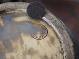 a close up of a metal drum with a coin on top of it
