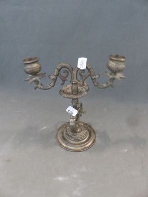un candélabre en métal surmonté de trois bougies